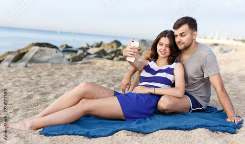 Happy loving couple resting and taking selfie