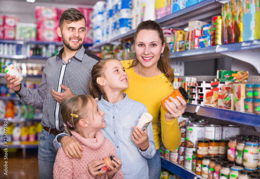 Parents with daughters choosing fresh products in food store
