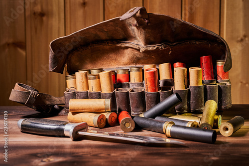 Old hunting cartridges and bandoleer on a wooden table