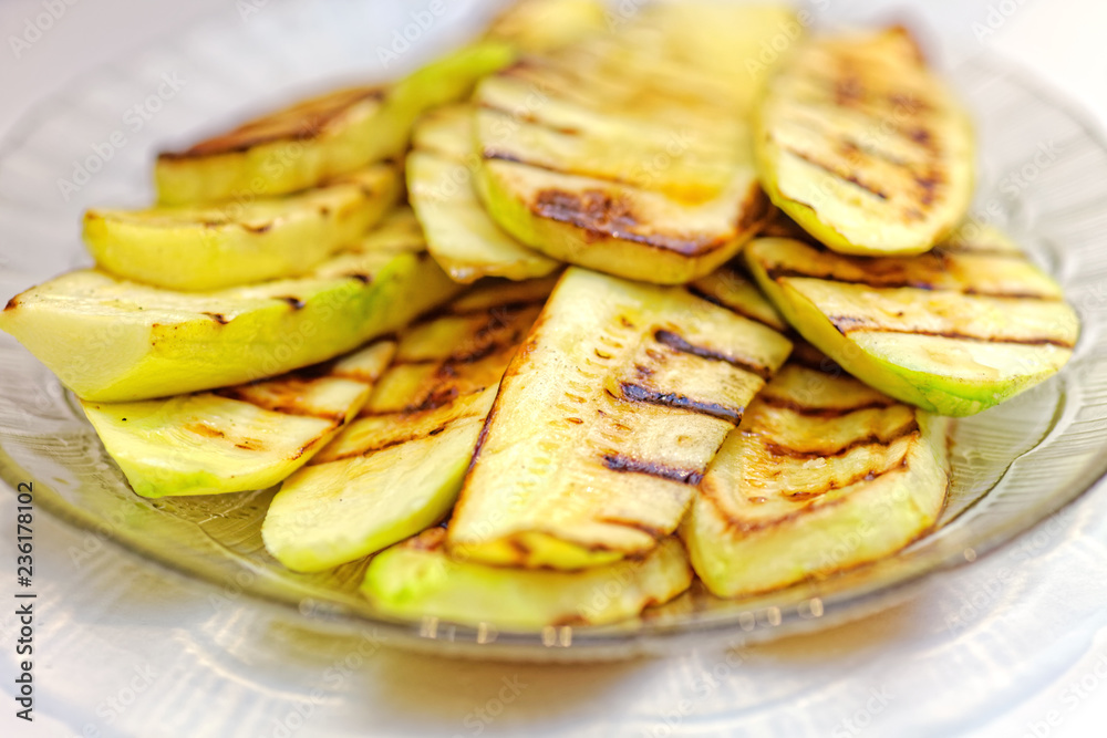 Close up grilled zucchini on plate. Macro of a vegetable. Shallow depth a field Close up grilled zucchini on plate. Macro of a vegetable. Shallow depth a field