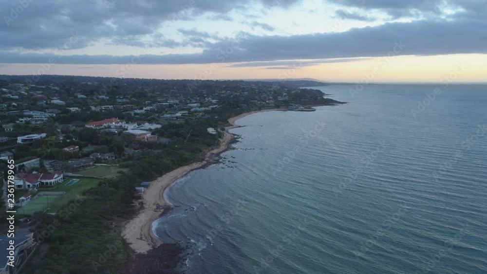 Slow descend over populated ocean coastline at sunset Slow descend over populated ocean coastline at sunset