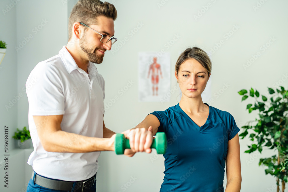 A Modern rehabilitation physiotherapy man at work with woman client
