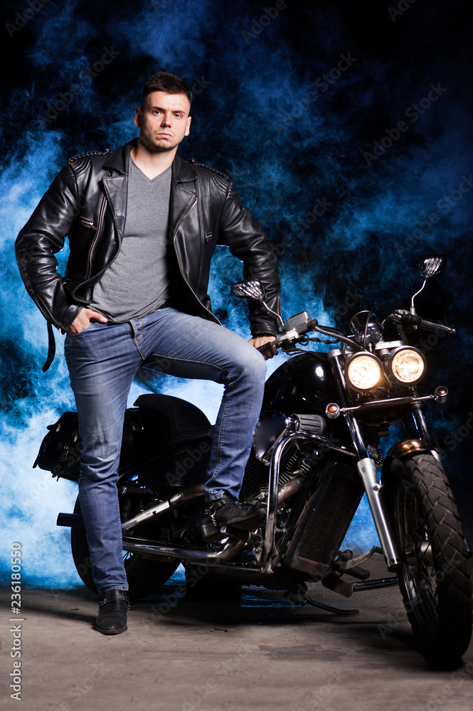 Cute motorcyclist stands near his motorcycle Cute motorcyclist stands near his motorcycle