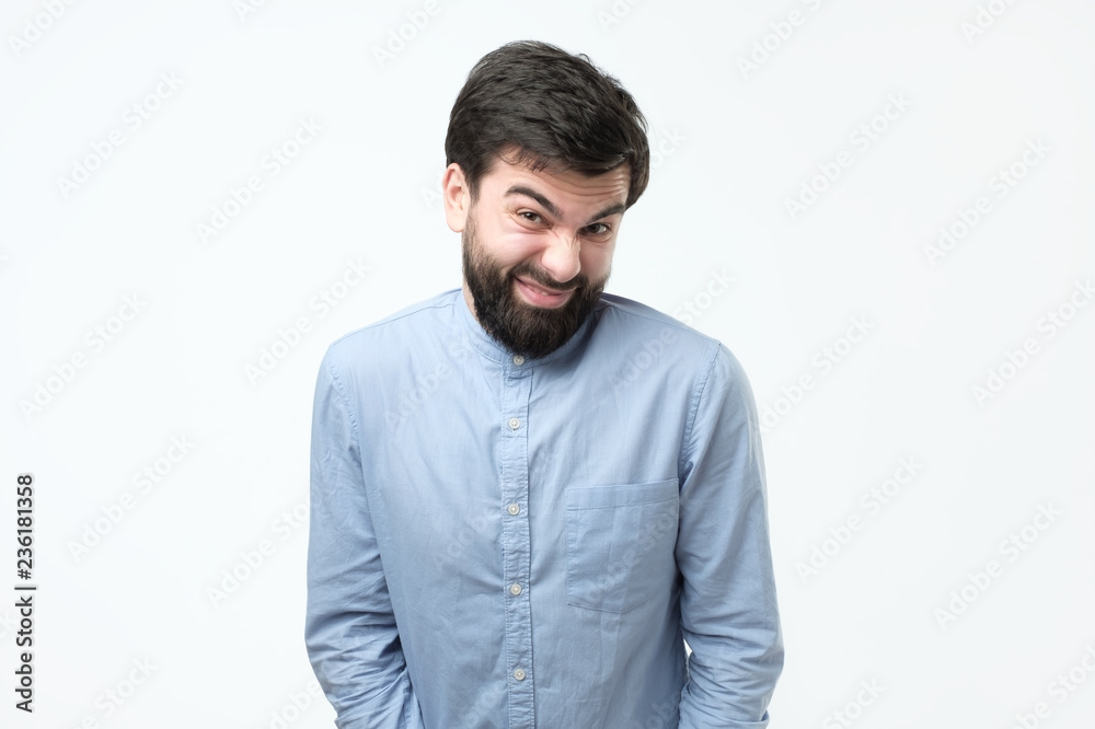 Sly young hispanic man imploring for a favor making a funny grimace. Sly young hispanic man imploring for a favor making a funny grimace.