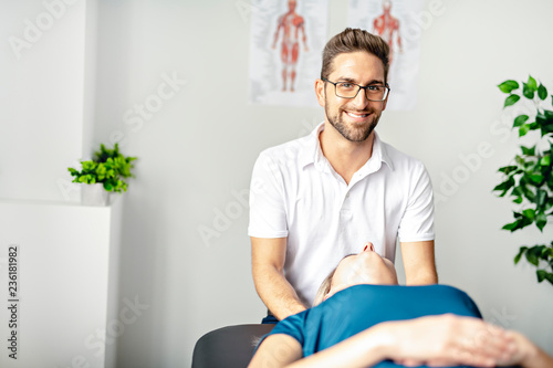 A Modern rehabilitation physiotherapy man at work with woman client working on neck photo