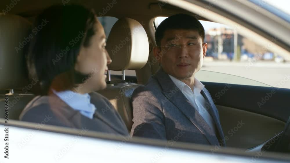 Medium shot of middle-aged man and woman sitting in car and having conversation with each other, handheld Medium shot of middle-aged man and woman sitting in car and having conversation with each other, handheld