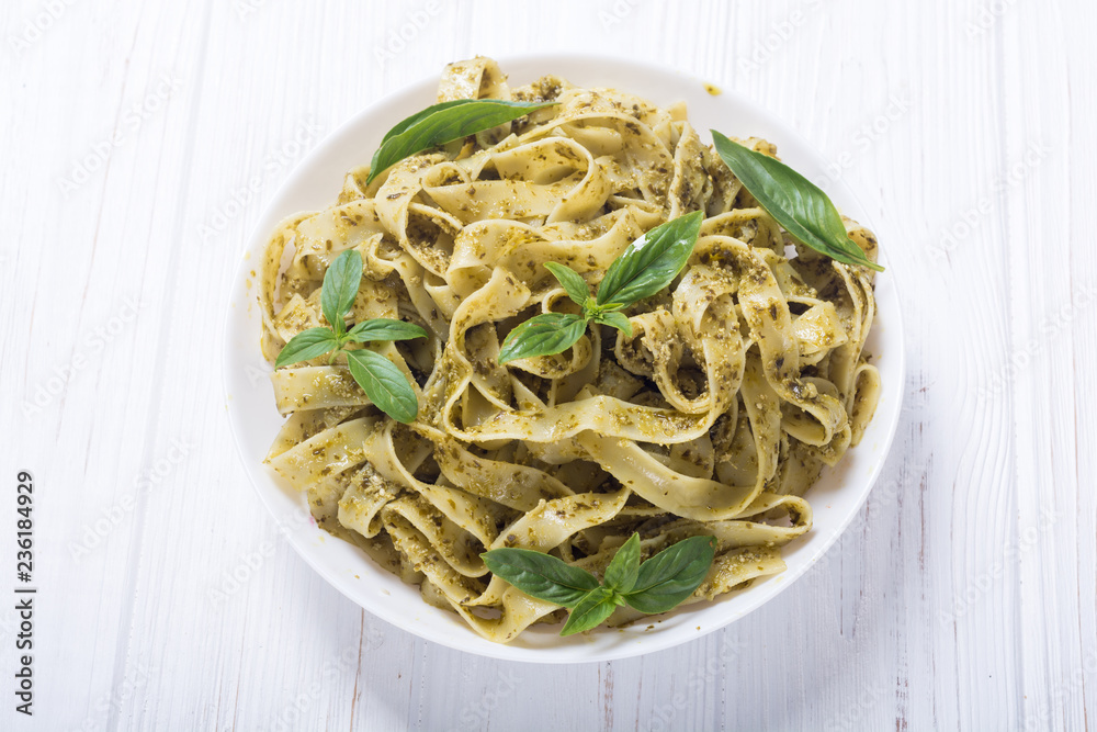 Pasta tagliatelle with green sauce pesto . Italian food background