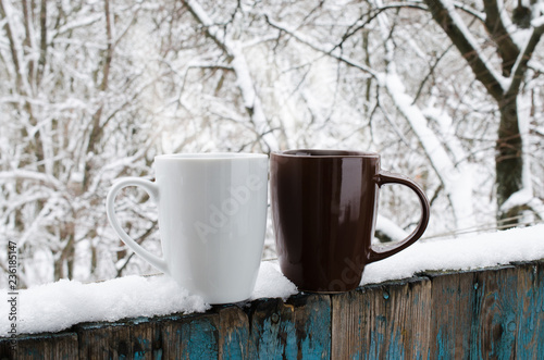 Two Cups of Hot Coffee or Tea on a Snow Covered Terrace.