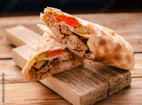 Shawarma sandwich gyro fresh roll of lavash (pita bread) chicken beef shawarma falafel RecipeTin Eatsfilled with grilled meat, mushrooms, cheese. Traditional Middle Eastern snack. On wooden background