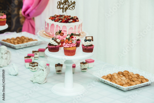 white stand with cupcakes on a candy bar table