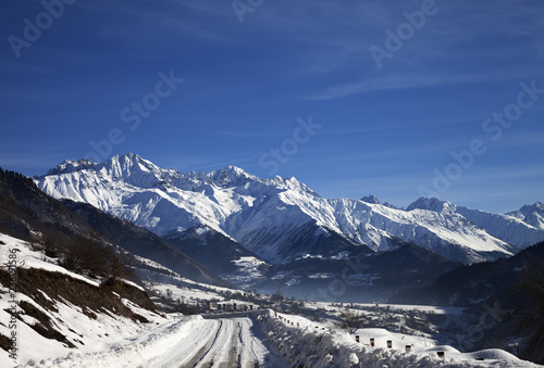 Snowy road and mountain in haze at early winter morning © BSANI