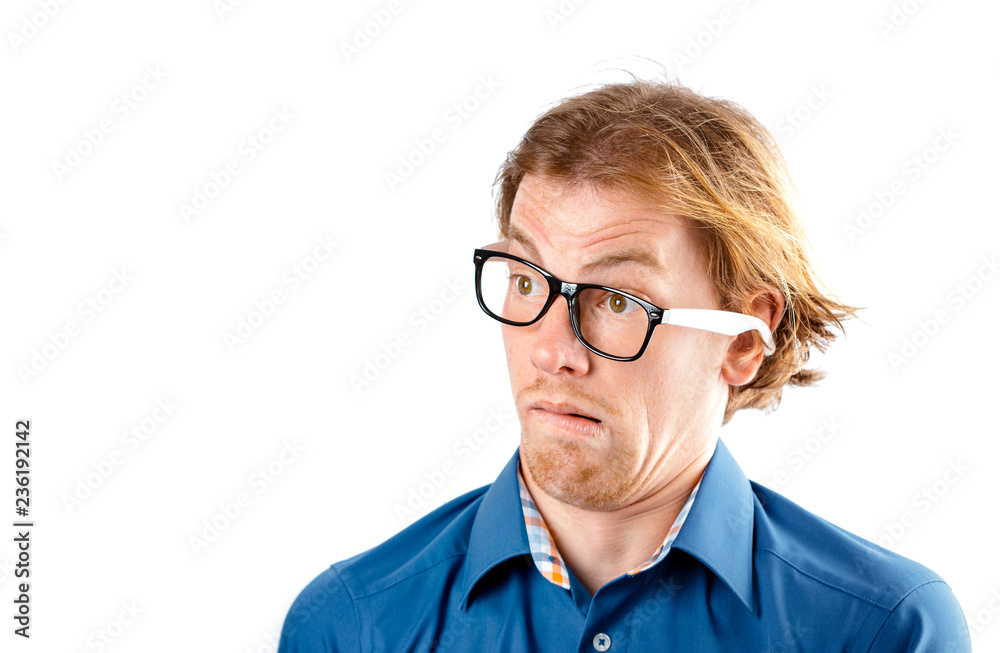 Male portrait of a fair-haired man of European appearance, on a white background. Emotions. Nerd hipster in eyeglasses sitting on a chair. Young worried nerd man. Stupid face. Botanist. Man in glasses
