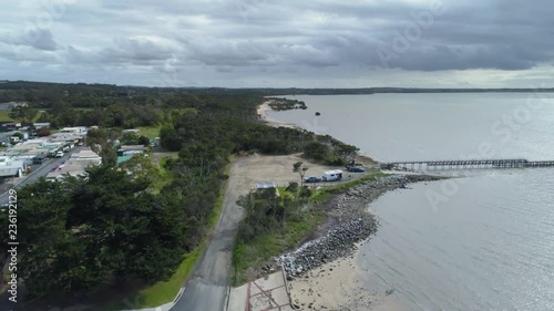 Slow rise above coastline and pier near Grantville, Victoria, Australia photo