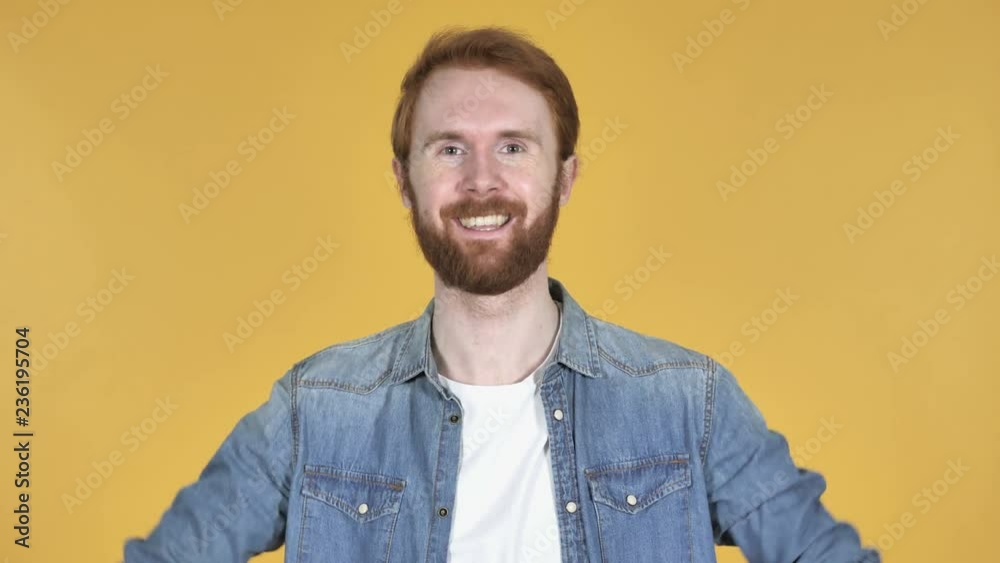 Redhead Man Gesturing Thumbs Up Isolated on Yellow Background Redhead Man Gesturing Thumbs Up Isolated on Yellow Background