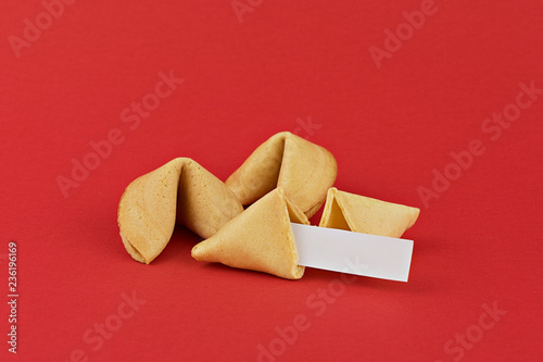 Traditional Chinese new year fortune cookies on red background with white paper for mottos