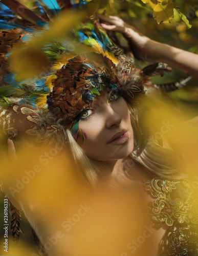Art portrait of a blond nymph posing in an autumnal park