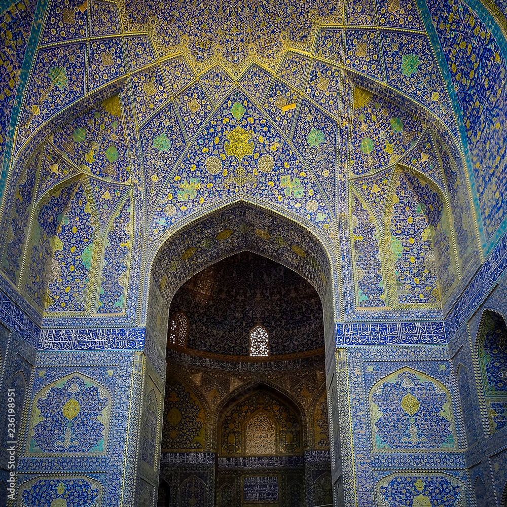A tall arch decorated with intricate blue mosaic artwork, at the UNESCO listed Imam Mosque, in Esfahan, Iran