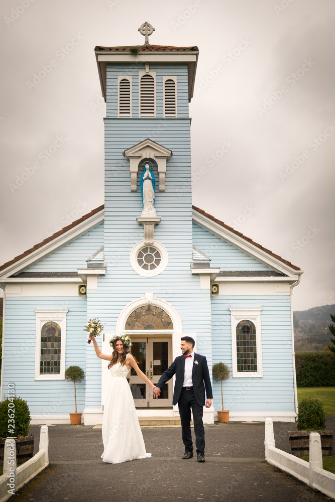 young couple bride groom getting married wedding posed photos at seaside sea beach hairpiece flowers bouquet church