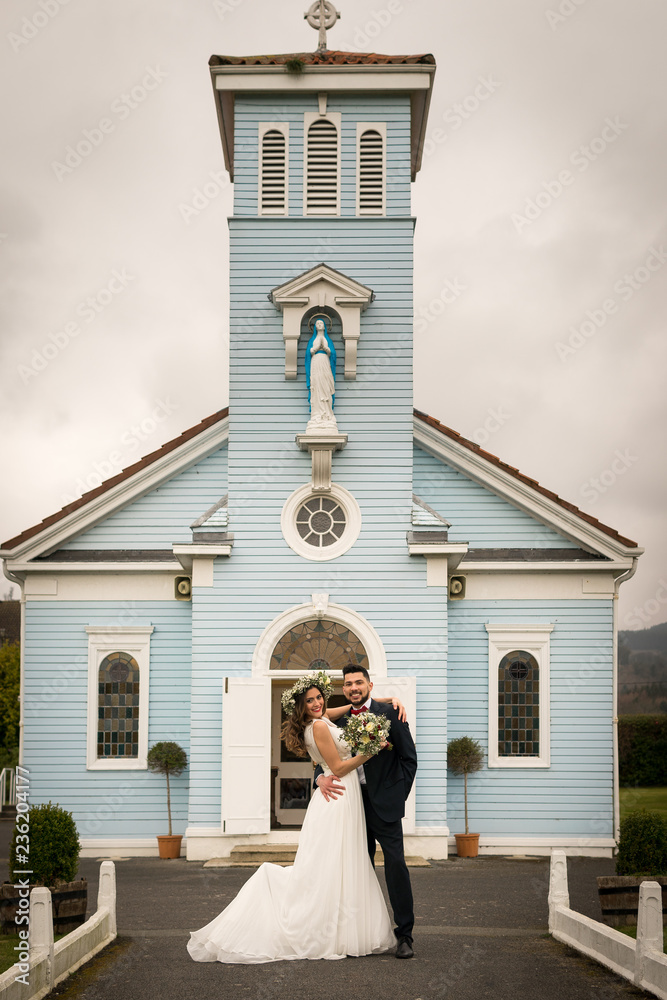 young couple bride groom getting married wedding posed photos at seaside sea beach hairpiece flowers bouquet church