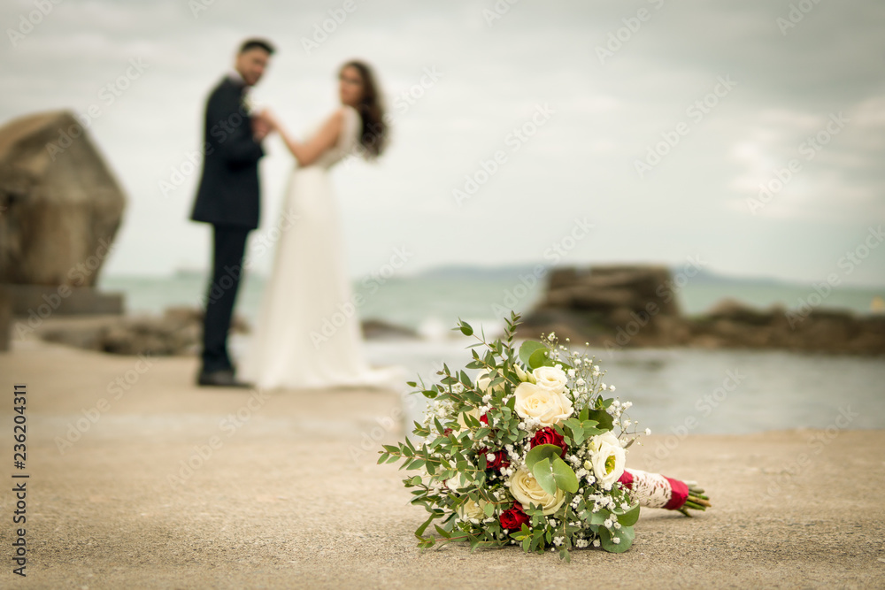 young couple bride groom getting married wedding posed photos at seaside sea beach hairpiece flowers bouquet church
