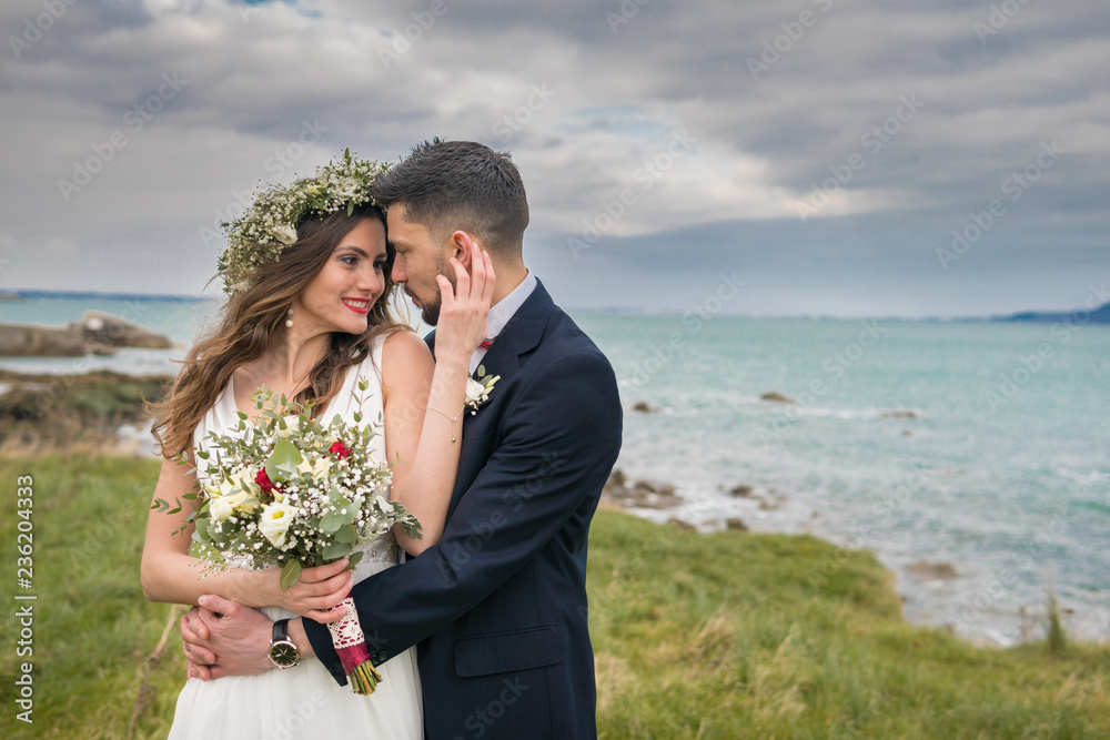 young couple bride groom getting married wedding posed photos at seaside sea beach hairpiece flowers bouquet church