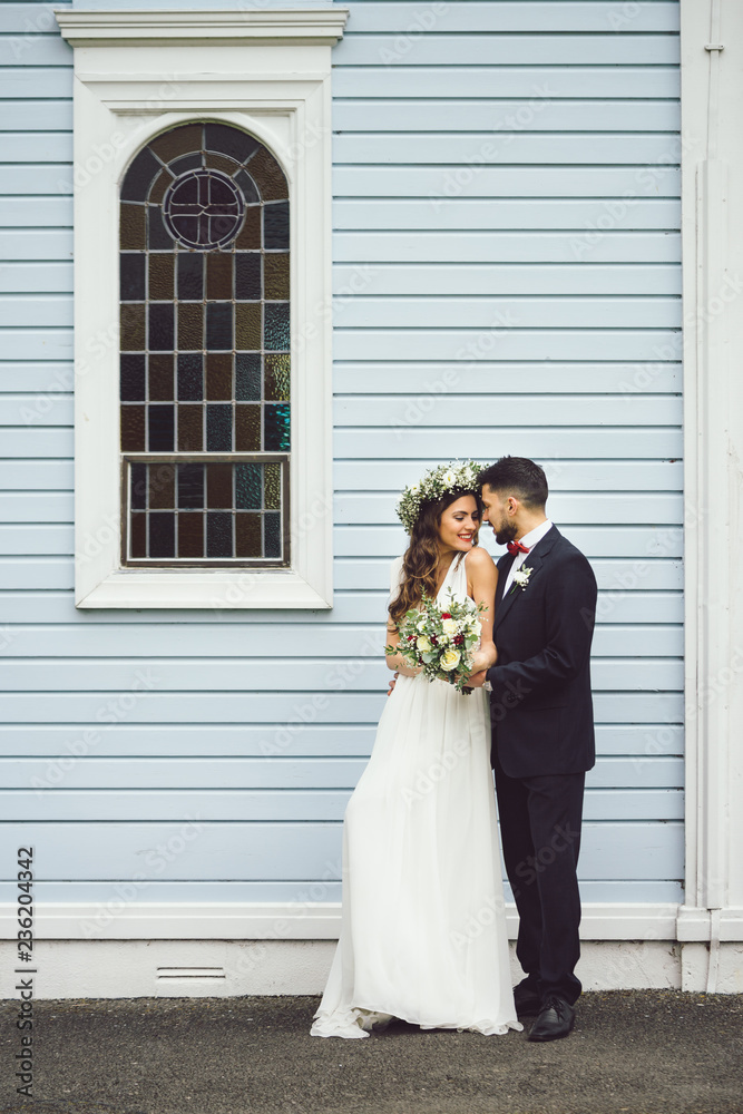 young couple bride groom getting married wedding posed photos at seaside sea beach hairpiece flowers bouquet church
