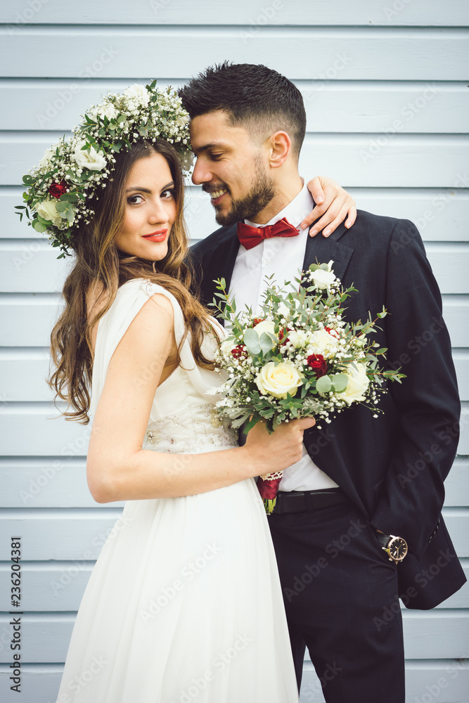young couple bride groom getting married wedding posed photos at seaside sea beach hairpiece flowers bouquet church