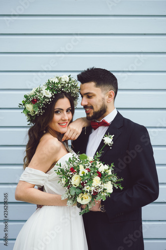 young couple bride groom getting married wedding posed photos at seaside sea beach hairpiece flowers bouquet church