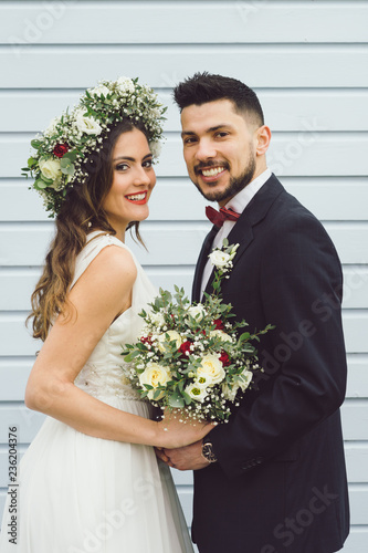 young couple bride groom getting married wedding posed photos at seaside sea beach hairpiece flowers bouquet church