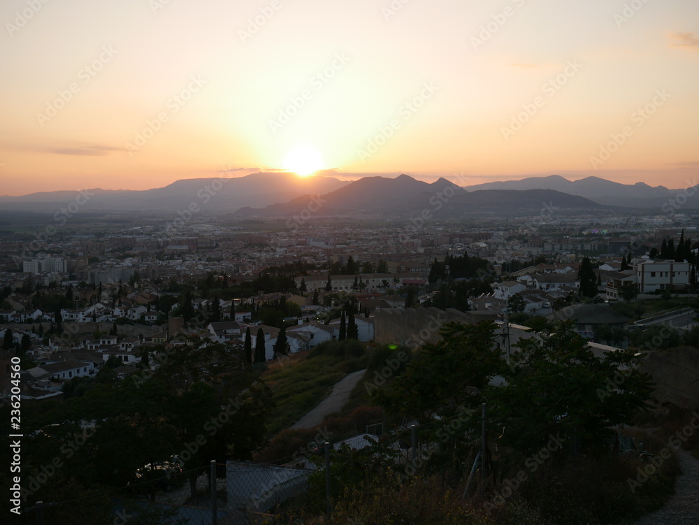 Panorama of a beautiful orange sunset over the city of Granada, Spain