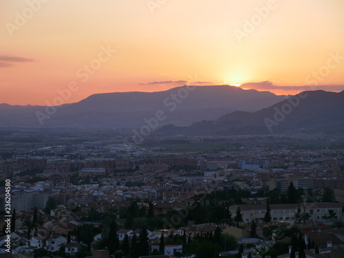 Panorama of a beautiful orange sunset over the city of Granada, Spain © duqimages