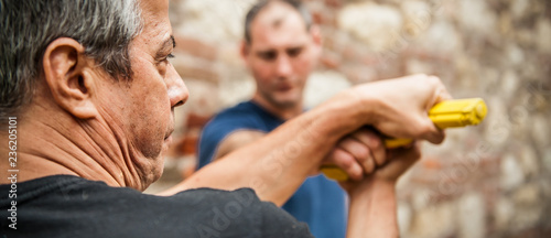 Gun point. Kapap instructor demonstrates self defense techniques against threat photo