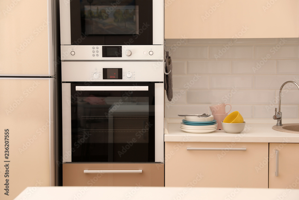 Fototapeta premium Clean dishware and cutlery on counter in kitchen