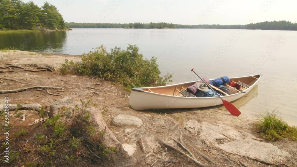 Canoe with paddle and camping equipment including backpacks on island beach. Massassauga Provincial Park, Ontario, Canada. Canoe with paddle and camping equipment including backpacks on island beach. Massassauga Provincial Park, Ontario, Canada.