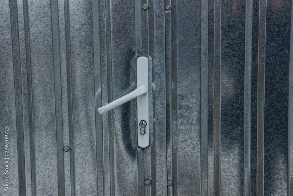 white plastic door handle on a gray metal door white plastic door handle on a gray metal door