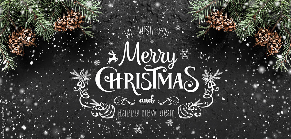 Christmas and New Year Typographical on dark holiday background with frame of Fir branches, pine cones, snowflakes. Xmas and Happy New Year theme, snow. Flat lay, top view Christmas and New Year Typographical on dark holiday background with frame of Fir branches, pine cones, snowflakes. Xmas and Happy New Year theme, snow. Flat lay, top view