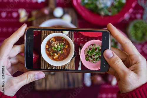 Take phone food photo with smartphone in woman hands, Photography for blogging, mobile social media publications and posts for cafes, restaurants. Borscht beetroot cabbage soup