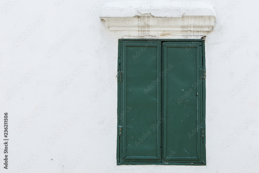 Old green wood window on a white wall