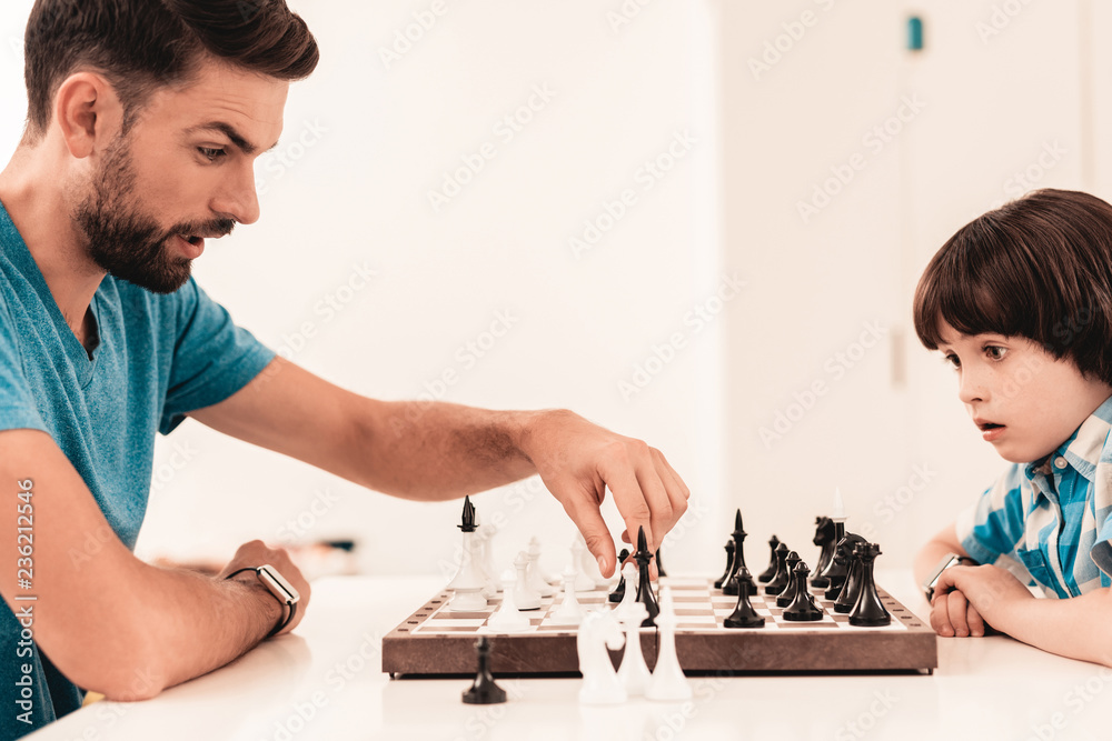 Bearded Father and Son Playing Chess on Table. Bearded Father and Son Playing Chess on Table.