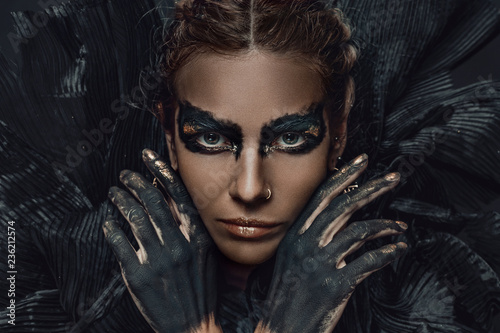 conceptual close up portrait of beautiful fashion look woman dark make up with gold photo