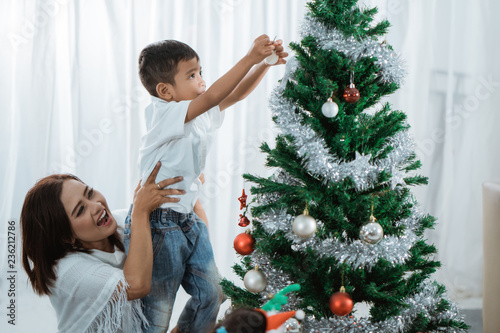 mother and son decorating christmas tree © Odua Images