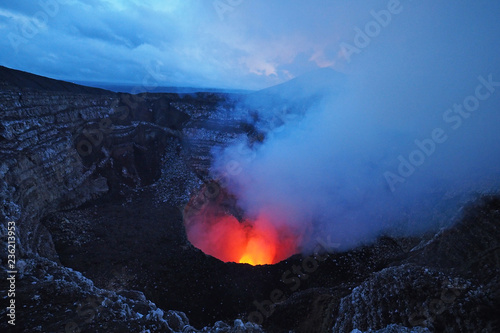 The active volcano in Masaya Volcano National Park, Masaya, Nicaragua, glowing red and yellow in the twilight. photo
