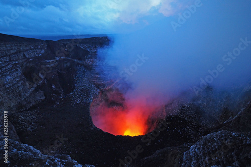 The active volcano in Masaya Volcano National Park, Masaya, Nicaragua, glowing red and yellow in the twilight.