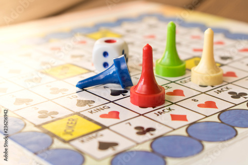 Multi-colored game chips with dice on the playing board. Board game