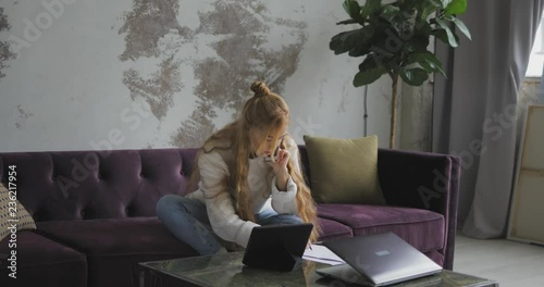 Young woman using phone and computer in home photo