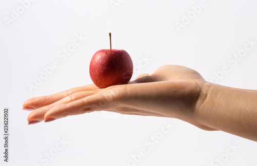 Small apple on the woman hand isolated.