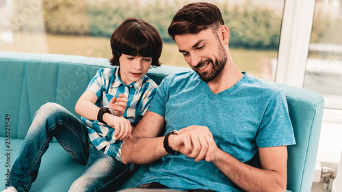 Little Boy with Father Wacthing on Hand Watches. photo