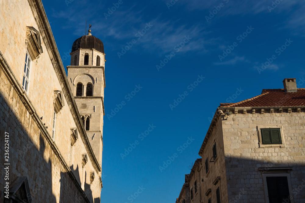 Sunshined tower of St. Saviour church on blue sky in Dubrovnik, Croatia