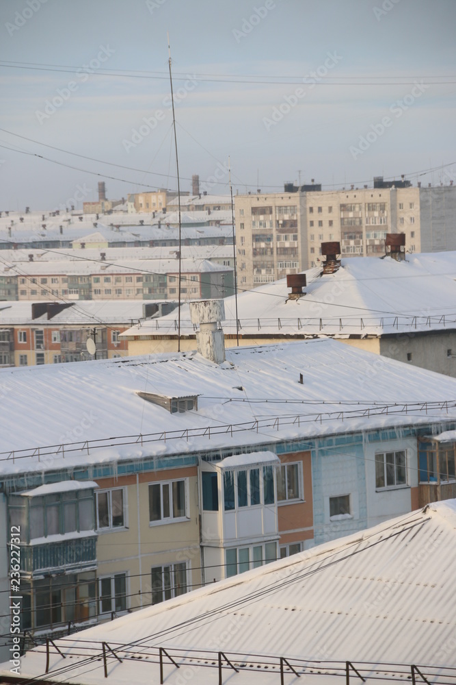 snow-covered roofs. winter city under blizzard