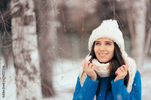 Happy Woman Applying Lip Balm Outdoors in Winter  photo